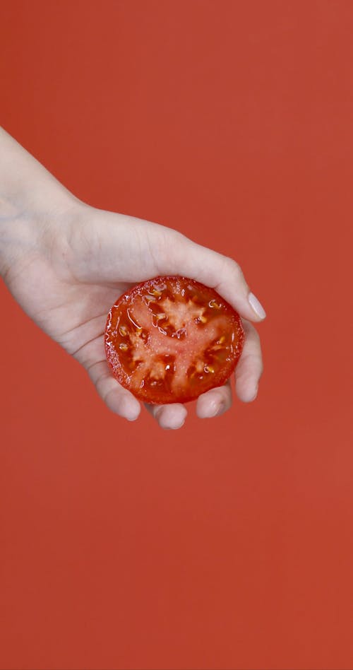 Squeezing A Sliced Tomato By Hand