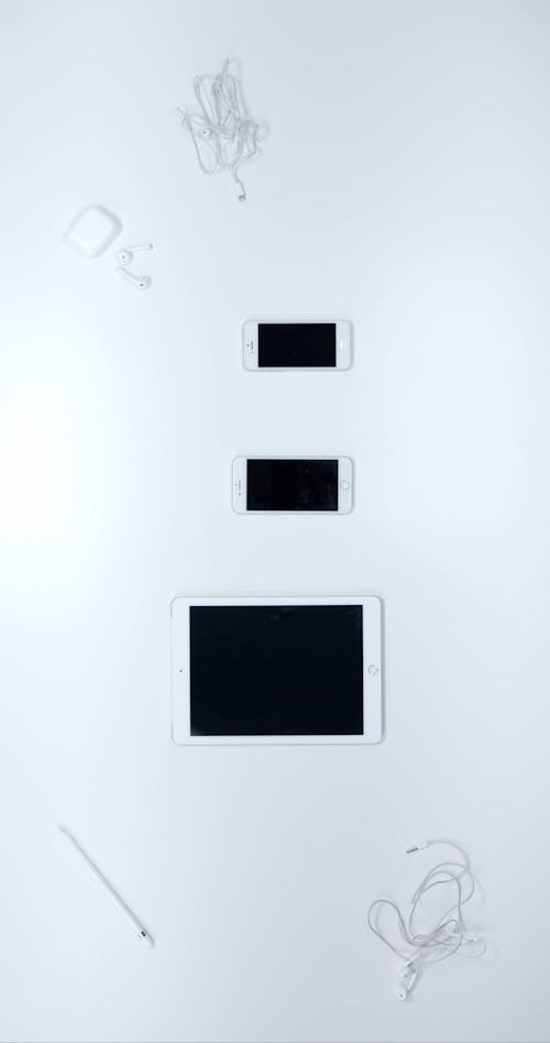 Apple Products Arranged Vertically Over A White Surface