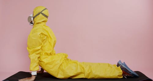 A Man Exercising While Wearing A Protective Suit And Gas Mask