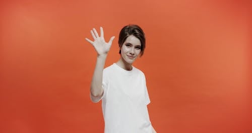 A Woman Raising A Hand Gesture Of  The Number Five