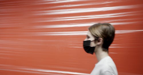 People Wearing Face Masks Isolated By A Plastic In A Room