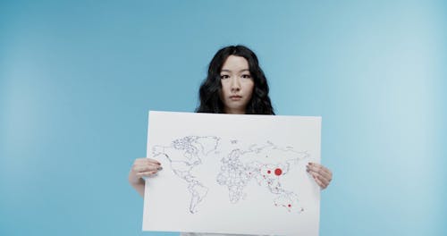 A Woman Showing A Map On The Spread Of Covid19