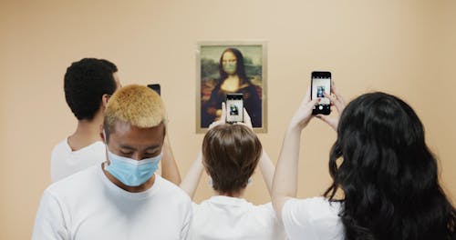 People Taking Pictures On A Painting Of Mona Lisa Wearing Face Mask