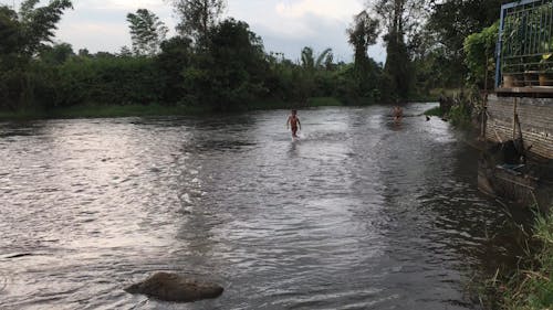 Kids Bathing In A Shallow River