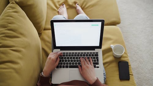 A Person Is Working On A laptop While Staying At Home