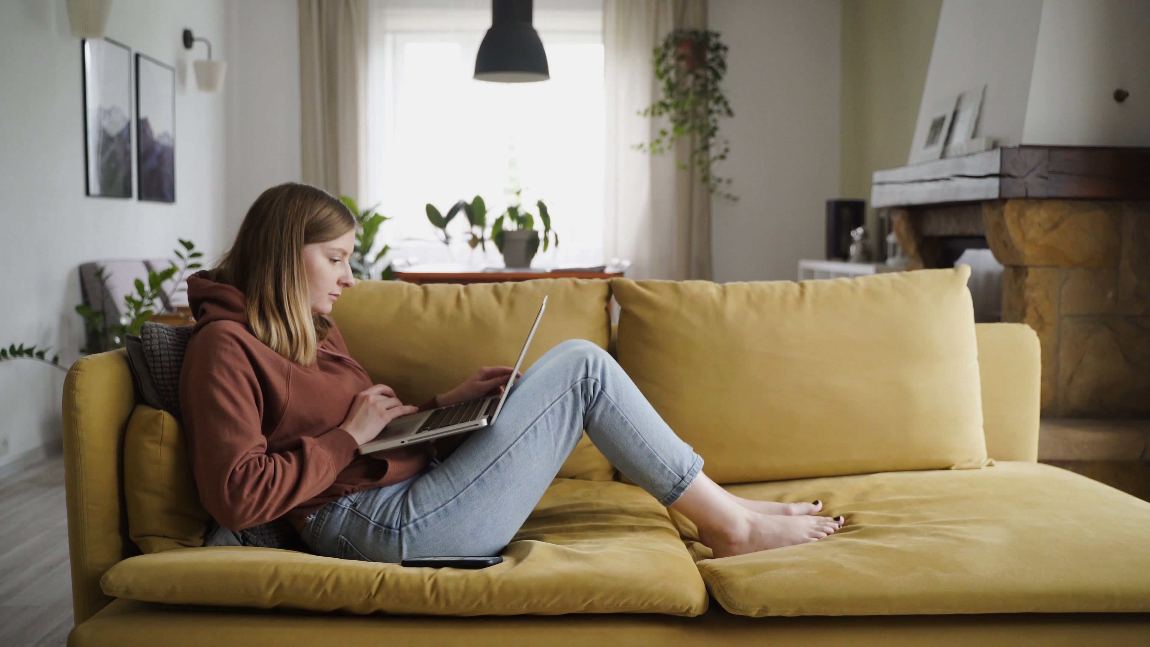 Woman On The Couch Scrolling Through Phone · Free Stock Video