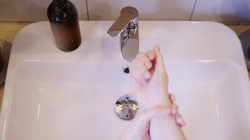 A Person Washing Hands With Soap And Water