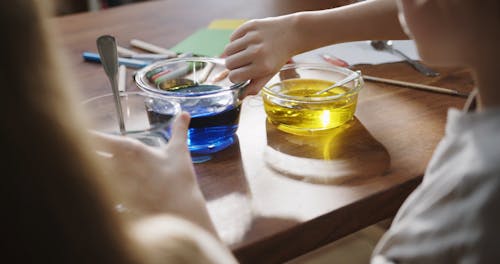 A Boy Is Mixing The Bowls Of Liquid Coloring