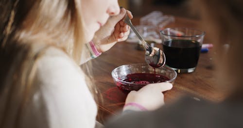A Girl Is Mixing A Bowl Of Red Liquid Coloring