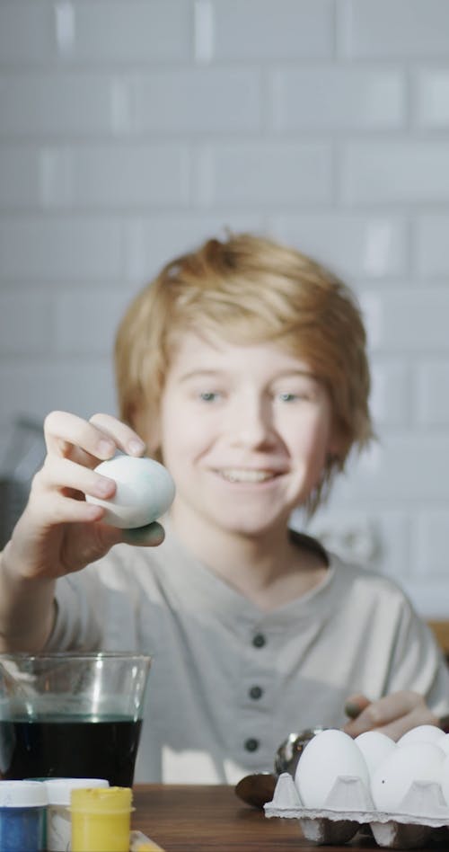 A Boy Rolling An Egg Around His Fingers