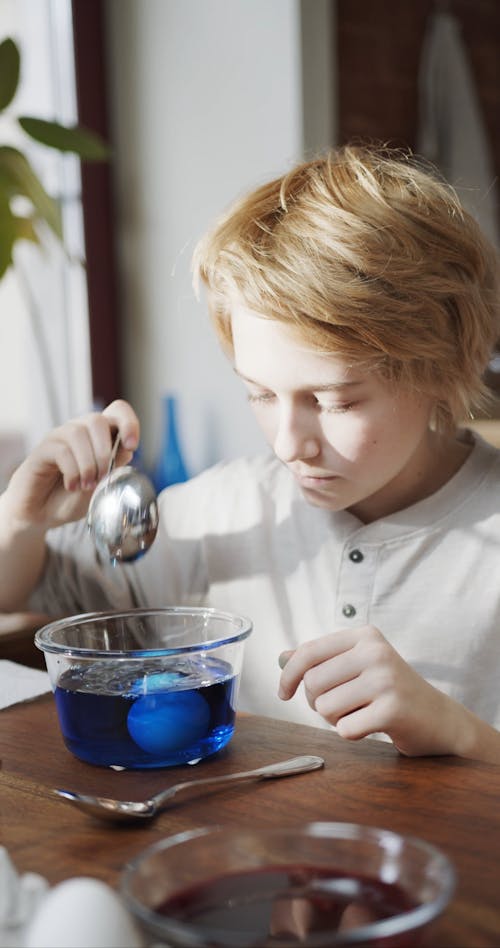 A Boy Stirring A Bowl Of Color Blue Liquid Coloring