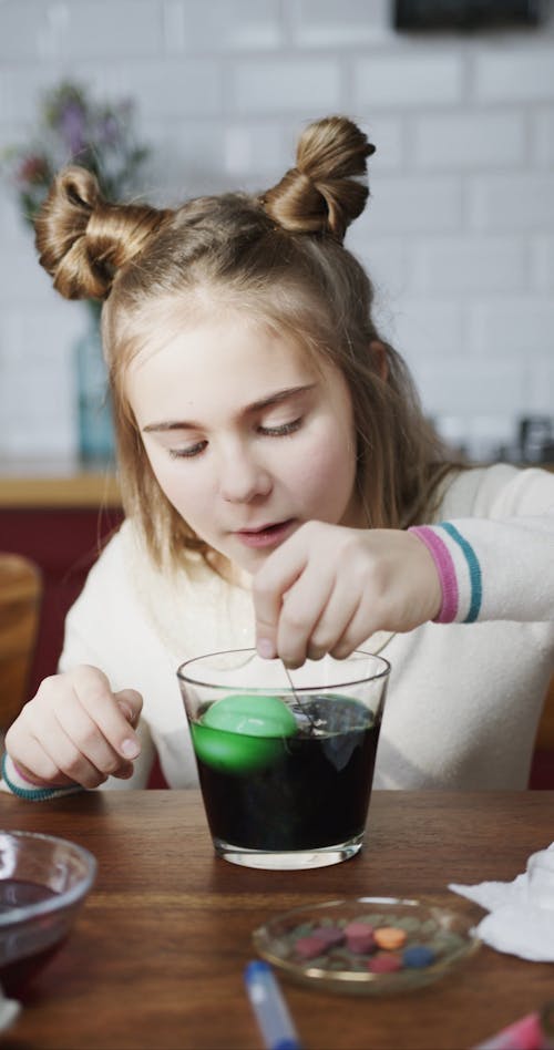 A Girl Scooping Out Egg From A Bowl Of Color Green Liquid Coloring