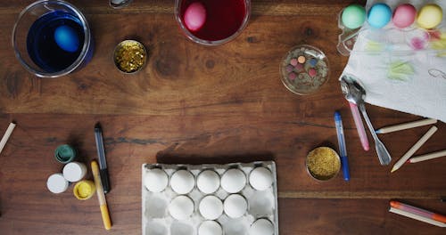 Placing Bowls Of Colored Liquid Over The Table For Dyeing White Eggs 