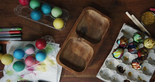 Placing Decorated Easter Eggs On A Wooden Bowl