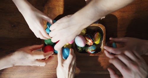 Picking Decorated Easter Eggs From A Wooden Bowl