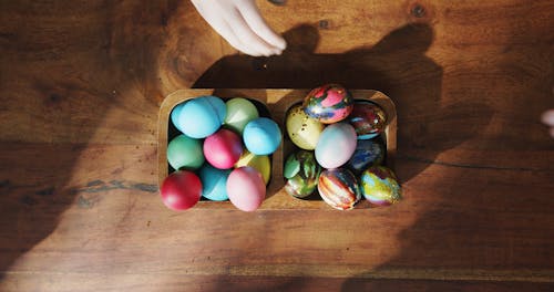 Picking Easter Egg From A Wooden Bowl