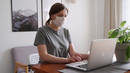 Woman Wearing Surgical Mask While Using The Computer