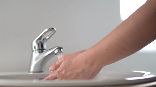 Slow Motion Footage Of A Person Using A Faucet