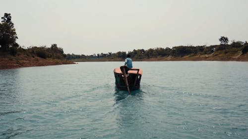 A Motorized Wooden Boat Traversing a River