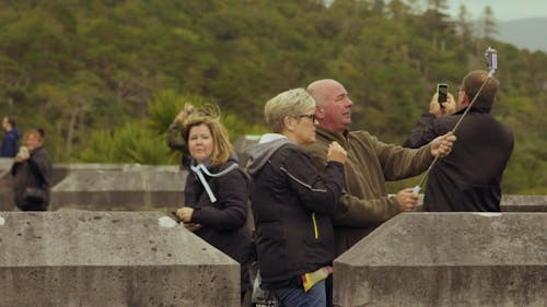 Tourist People Taking Photo while on a Mountain View