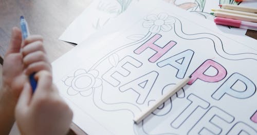 A Girl Coloring A Happy Easter Sign