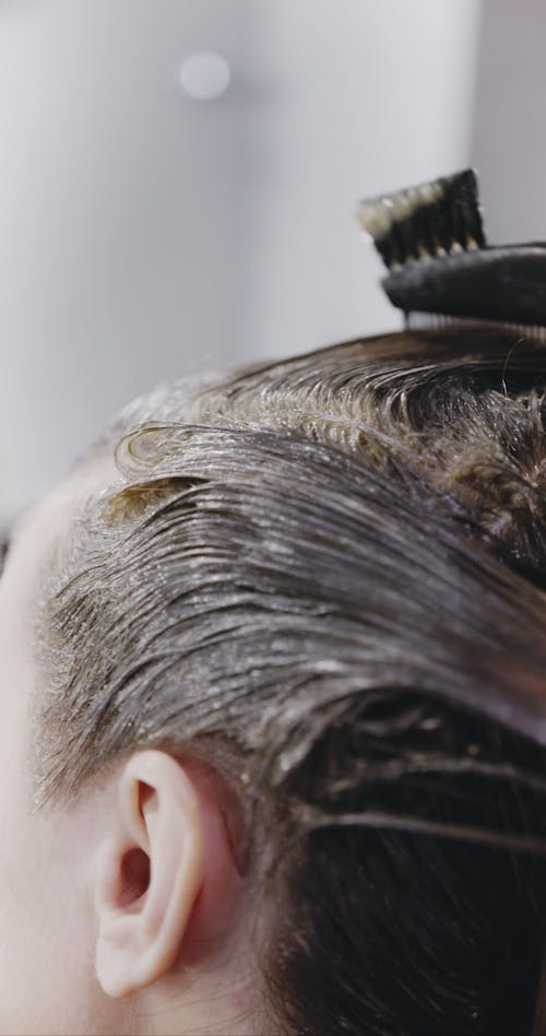 A Woman Having A Hair Coloring Treatment In A Salon