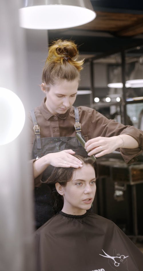 A Hairdresser Styling A Woman's Hair