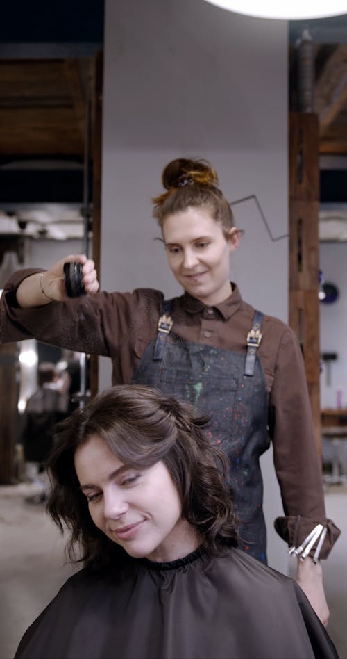 A Woman Applying Dry Shampoo On A Clients Hair