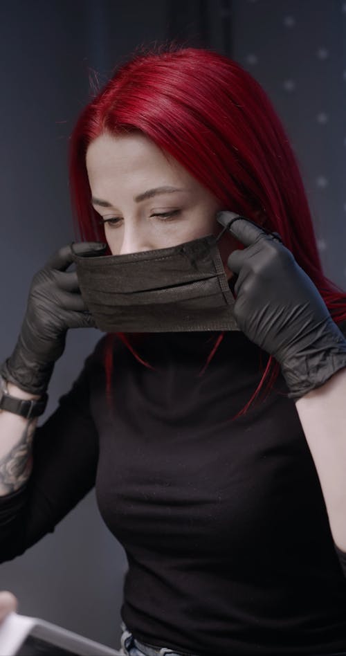 A Manicurist With Red Hair Wear A Face Mask Before Doing A Nail Polish Service To A Client