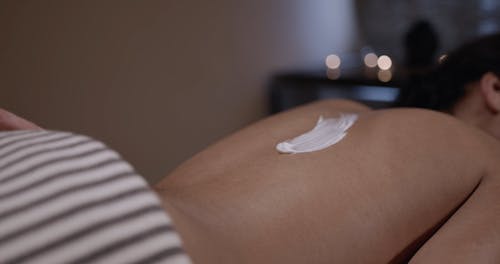 Rubbing A Massage Cream On A Woman's Back