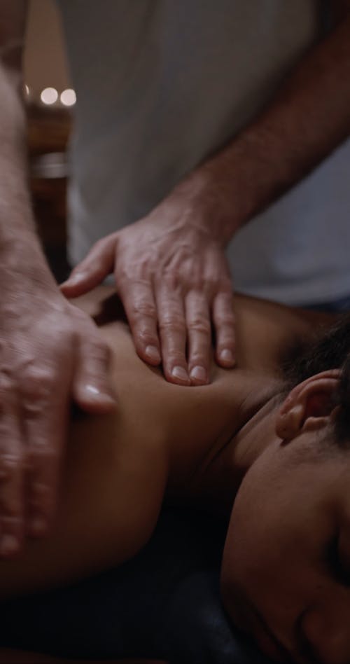 A Masseur Skillfully Rubbing A Woman's Back 