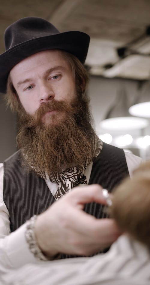 Man Trimming The Beard And Moustache Of His Customer