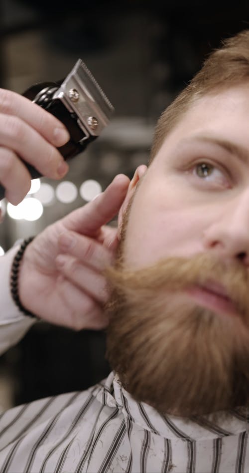 A Barber Using A Razor For Shaving A Man's Side Hair