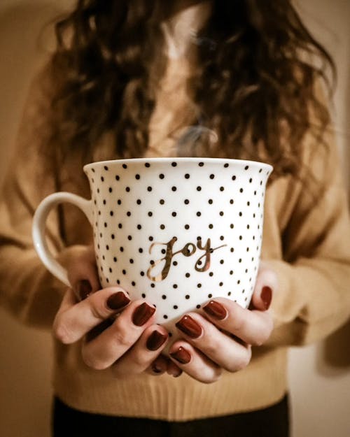 A Woman Holding A Cup Of Hot Coffee