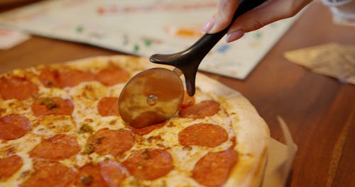 Slicing A Pizza With A Pizza Cutter