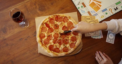 Slicing A Pizza With The Use Of A Pizza Cutter