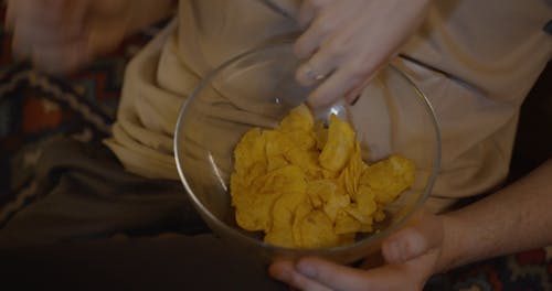 A Couple Sharing A Bowl Of Chips