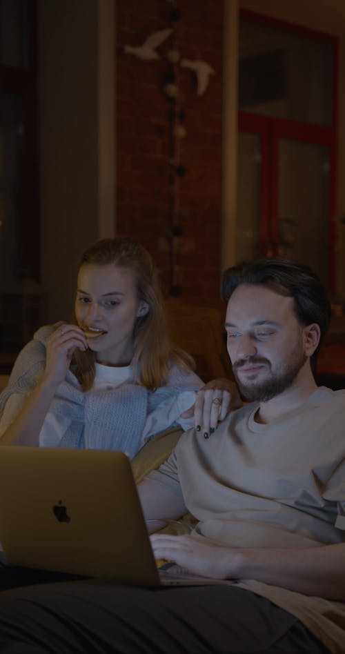 A Woman Watching Her Husband Work In His Laptop 