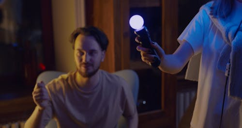 A Man Teaching His Partner How To Play A Virtual Reality Game