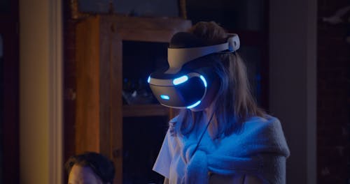 A Man Helping Her Partner Play The Virtual Reality Game
