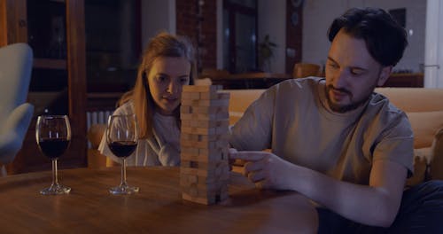 A Couple Playing A Game Of Jenga While Staying At Home