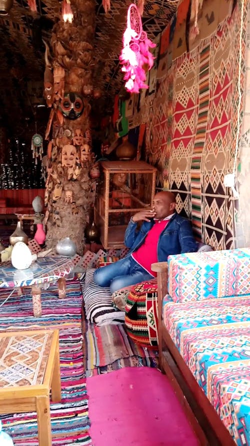 A Man Smoking  in a Carpet Shop