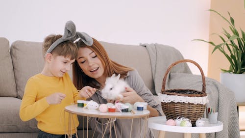 A boy Feeding A Rabbit With Dried Hay