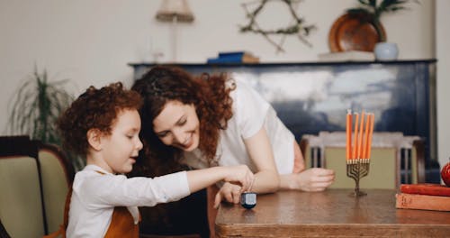 A Mother Watching Her Child Spin A Top