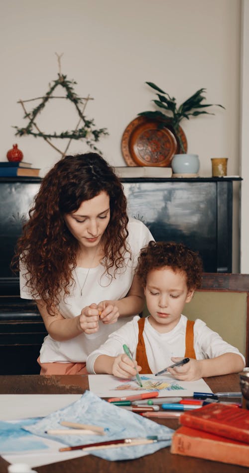 A Young Boy Coloring Drawings While Staying At Home