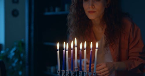 A Red Hair Woman Doing Jewish Traditional Ritual With Lighted Candles