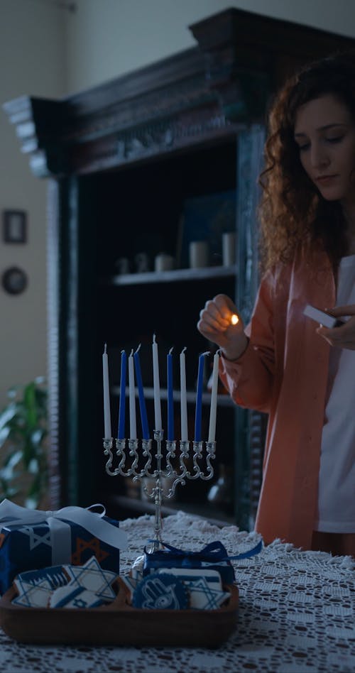 A Woman Lighting A Candle