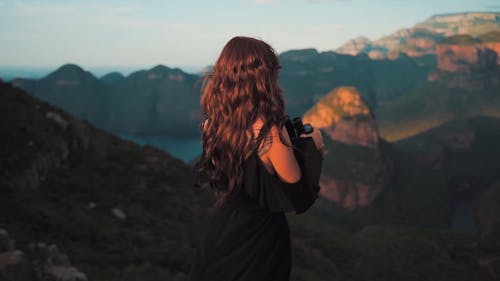 A Woman Using Binoculars To Enjoy The Mountain Scenery