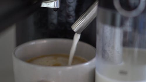Milk Pouring into a Cup of Brewed Coffee