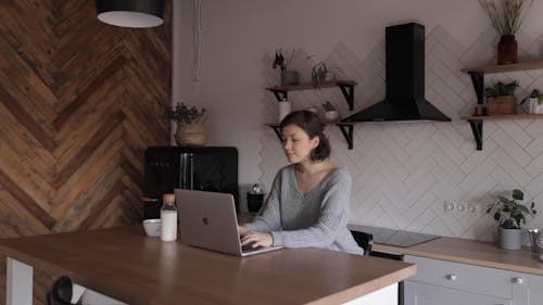 A Woman Typing on a Laptop